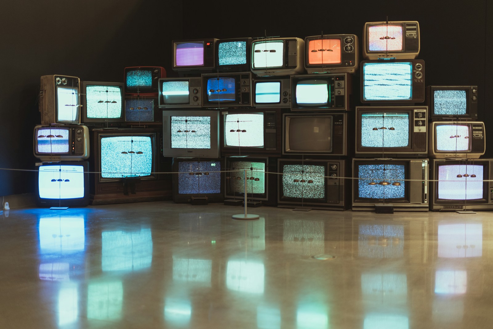 Multiple vintage TVs with colorful static on screen, symbolizing the nonsensical nature of the Korean slang eojjeol-tv.